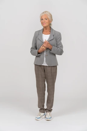 Front view of a happy old lady in suit looking at camera