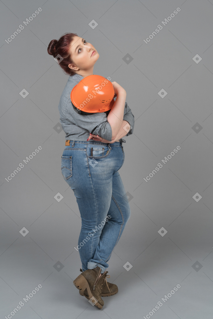 Woman dreaming with safety helmet in hand