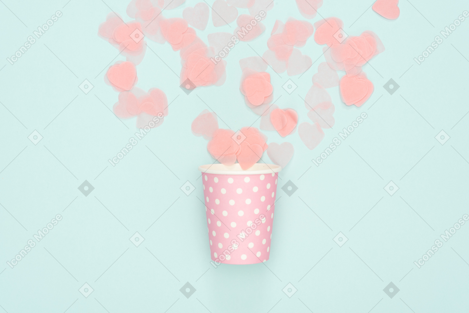 Confetti scattered from polka dot pink paper cup