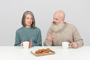 Homme âgé faisant remarquer quelque chose à sa femme