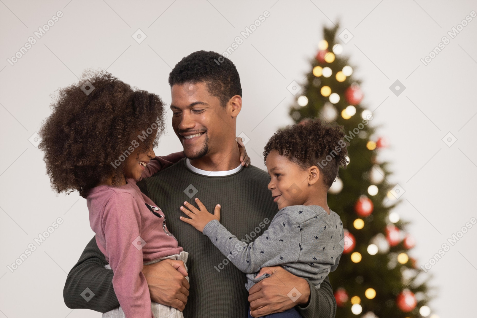 Счастливый отец с детьми возле елки