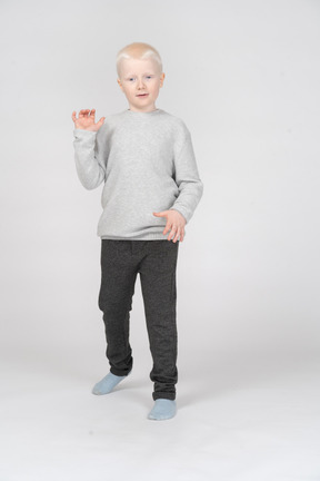 Little boy standing and making hand gestures