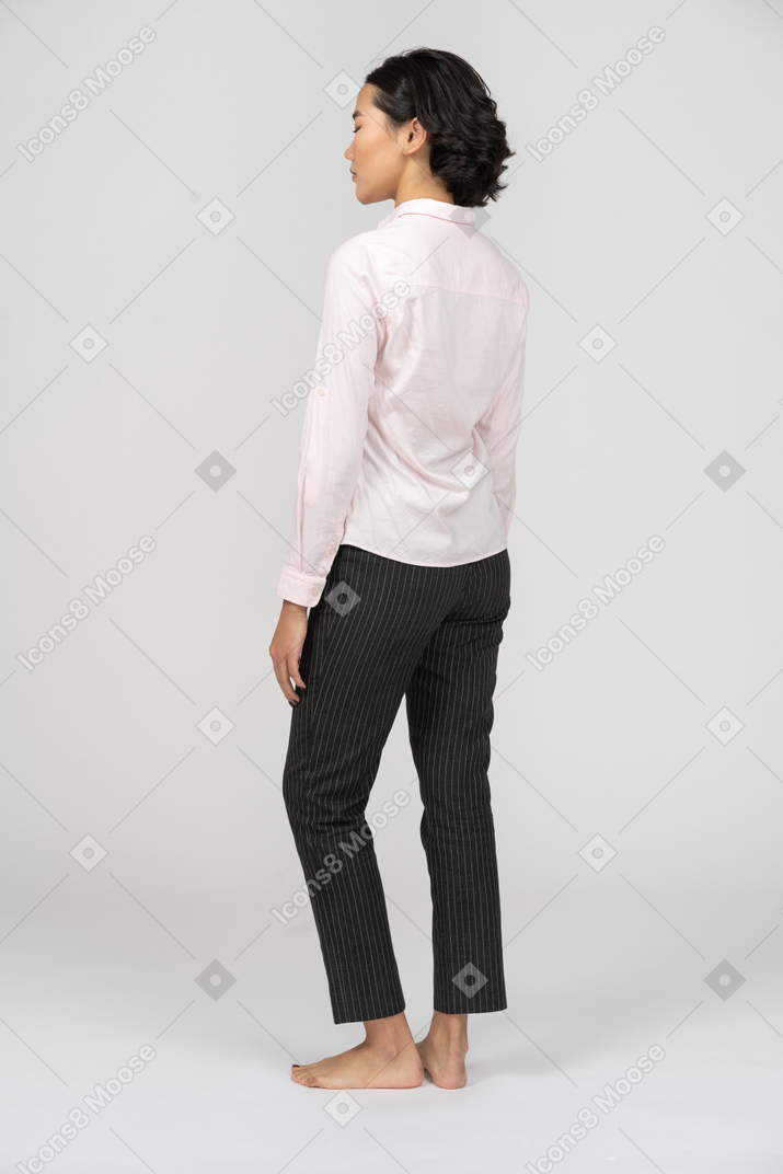 Vista traseira de uma mulher em pé de roupas de escritório