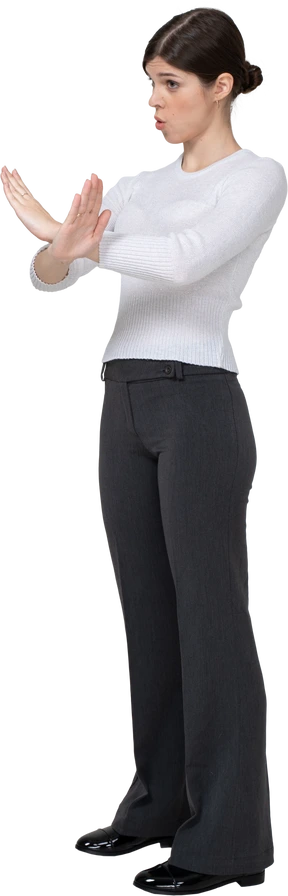 Three-quarter view of a young woman in office clothing crossing arms
