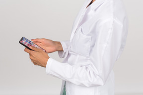 Женщина-врач держит смартфон