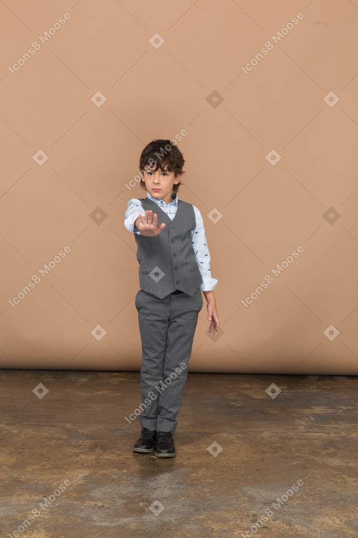 Vorderansicht eines jungen im grauen anzug mit stoppgeste