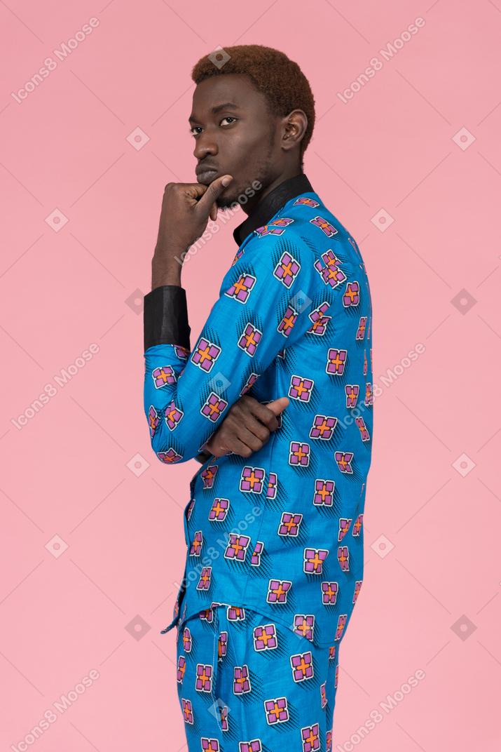 Черный мужчина в синей пижаме стоит