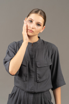 Front view of a young woman in a jumpsuit removing make-up