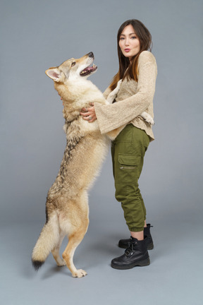 Side view of a female master embracing her dog