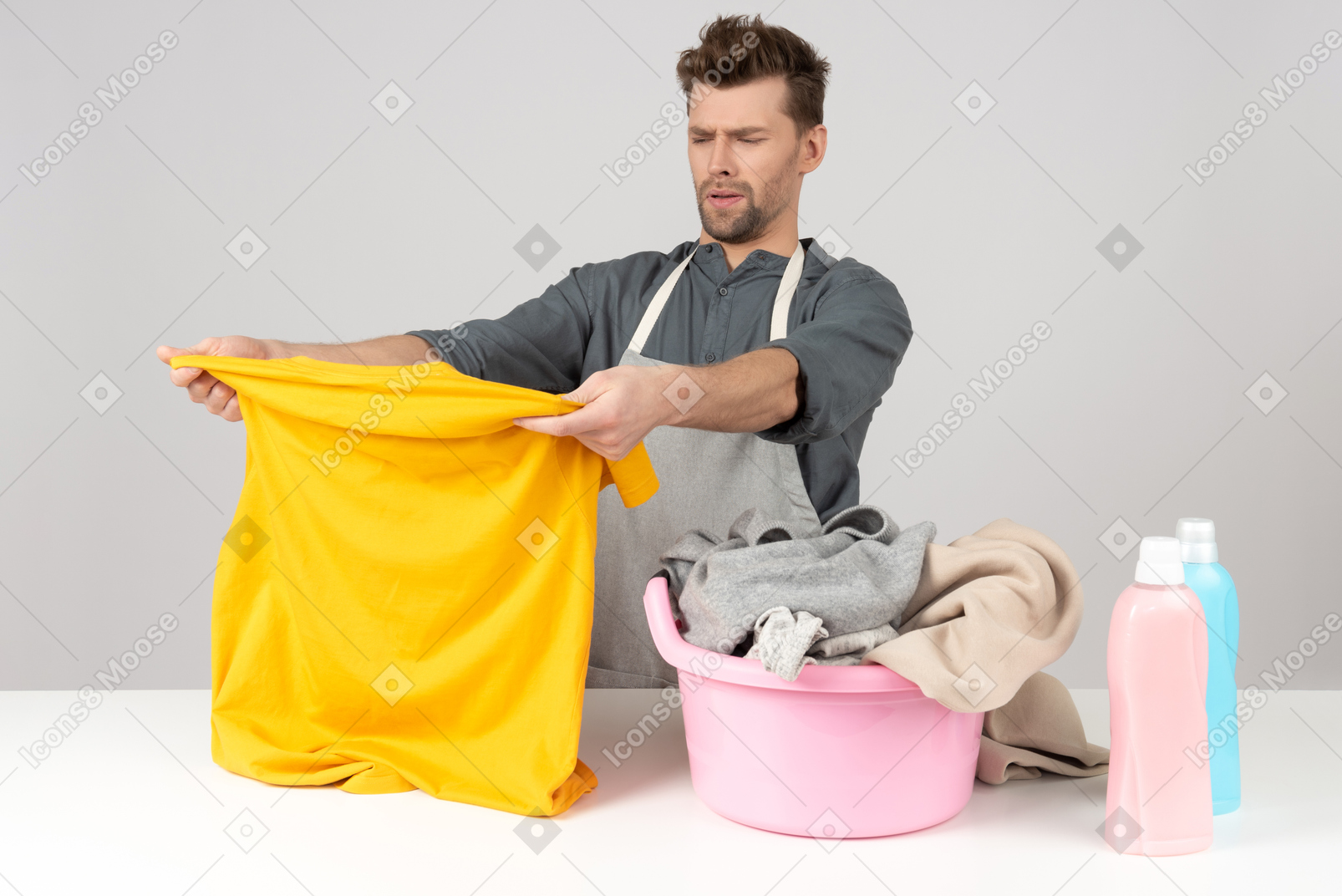 Young househusband sorting clothes for washing