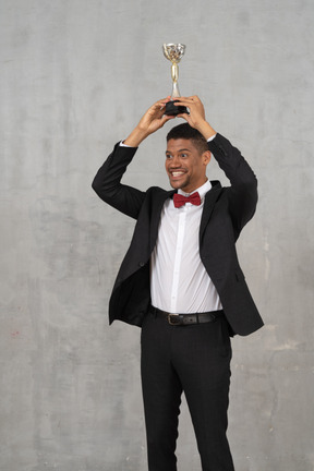 Man holding up award in celebration of his win