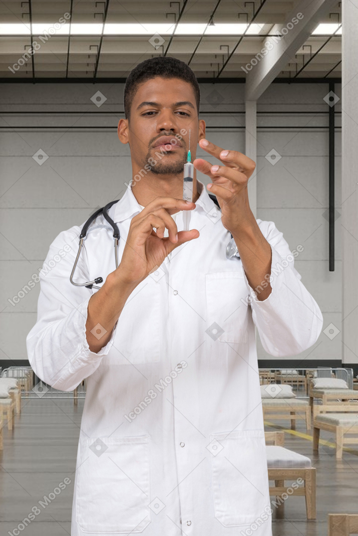 Man in a white laboratory coat holding a syringe