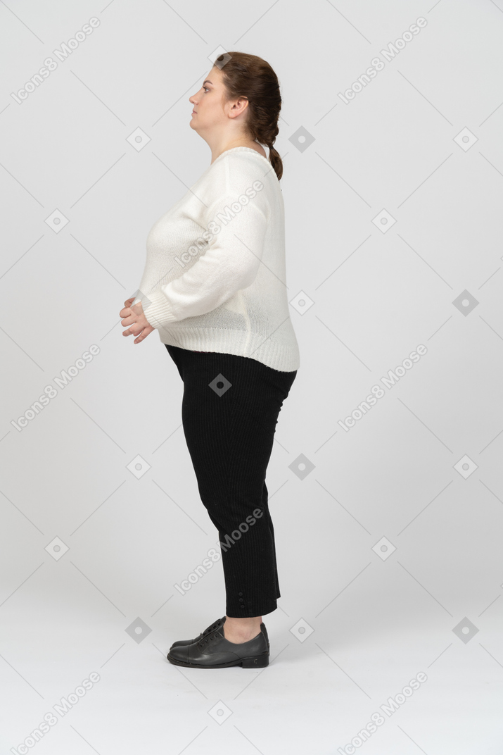 Side view of a plump woman in casual clothes standing