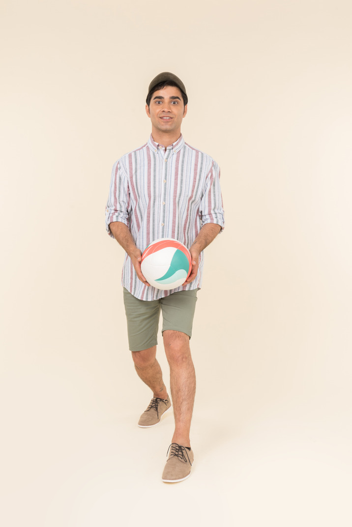 Surprised young caucasian man holding ball
