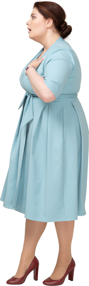Вид сбоку впечатленной женщины в синем платье