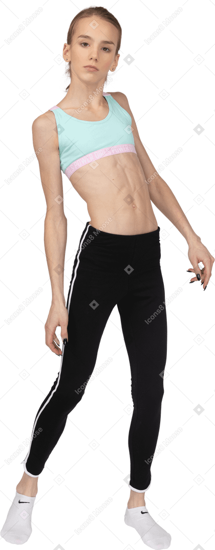 Front view of a teen girl in sportswear tilting shoulders