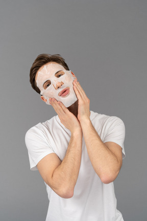 Front view of a young man posing in facial mask