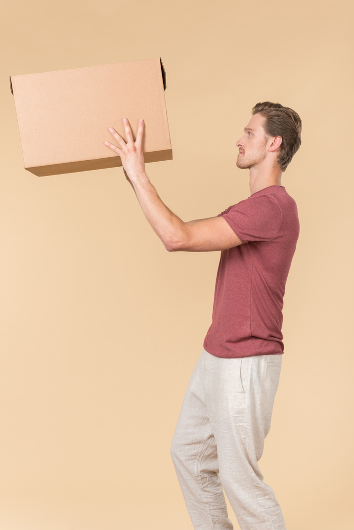 Delivery guy standing in profile and putting a parcel up