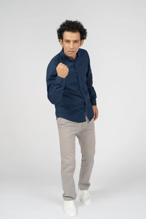 Front view of a man in casual clothes showing fist