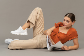 Mujer joven acostada y leyendo