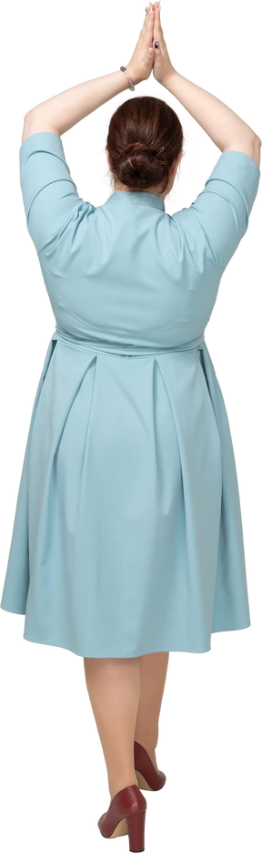 Rear view of a woman in blue dress making praying gesture