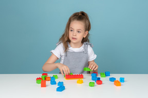 Little girl playing with lego blocks