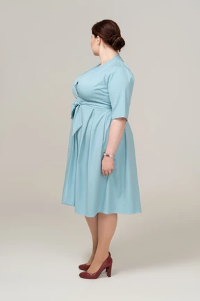 Woman in blue dress standing in profile