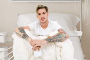 Young man sitting on a hospital bed