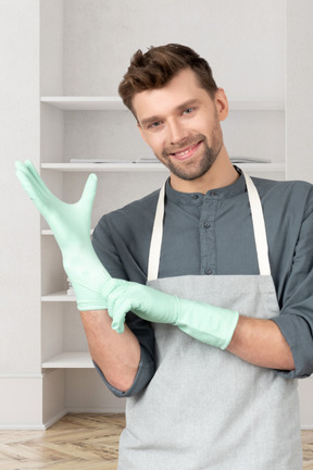 A man in an apron is putting on a glove