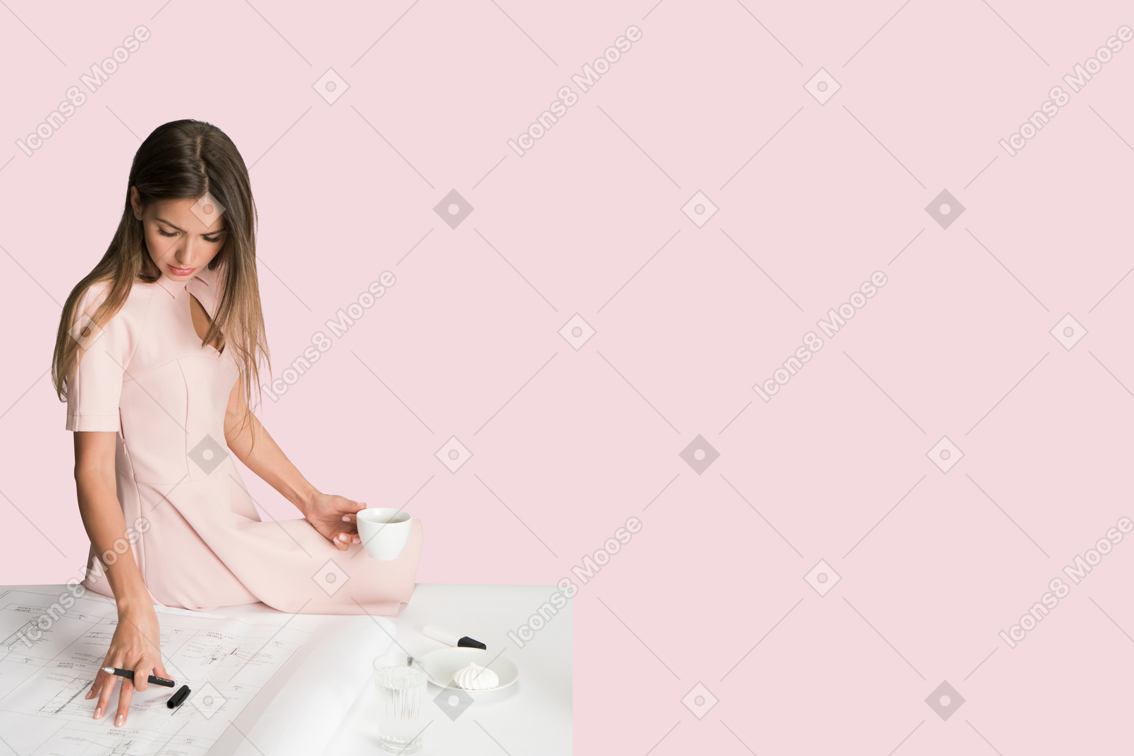 A woman in a pink dress sitting on a table with a cup of coffee
