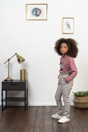 Cute girl kid posing on the apartments background