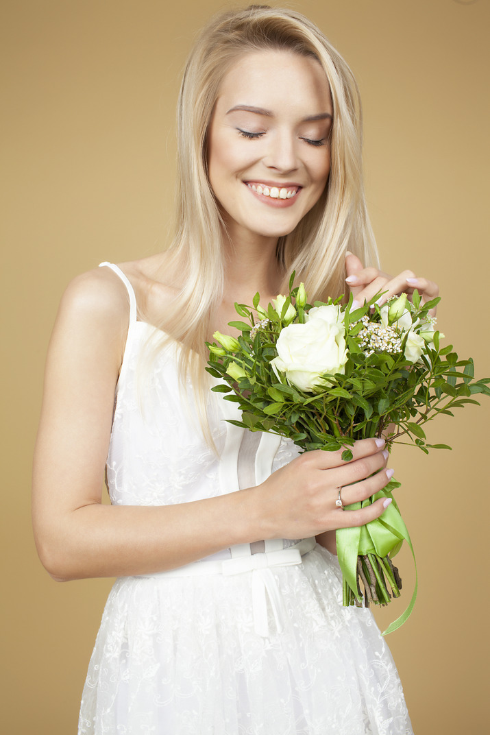 Beautiful young bride holding bouquet of white flowers
