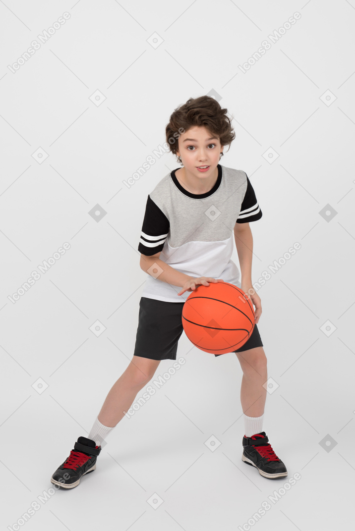 Boy hitting a basketball ball and ready to pass