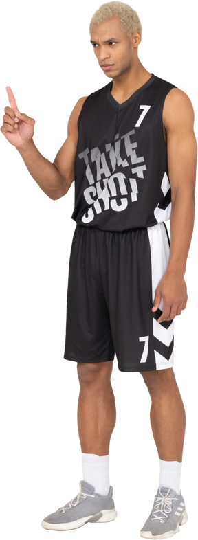 Vista di tre quarti di un giovane giocatore di basket maschile che punta il dito