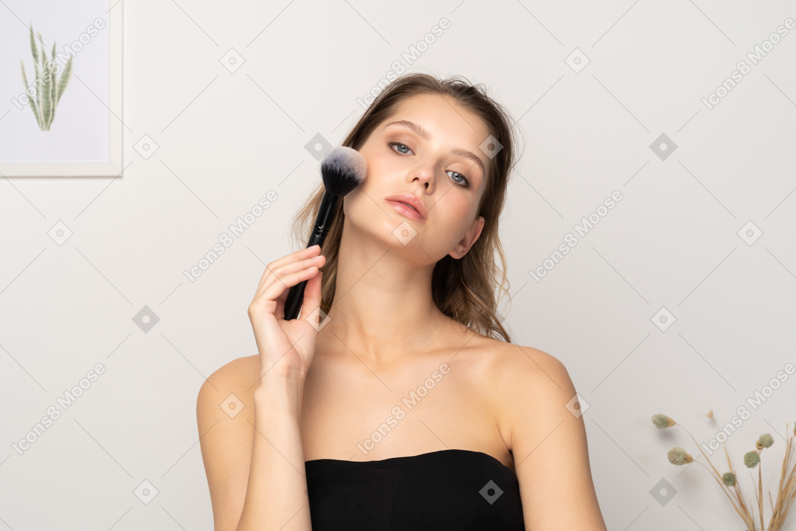 Vorderansicht einer sinnlichen jungen frau mit einem make-up-pinsel