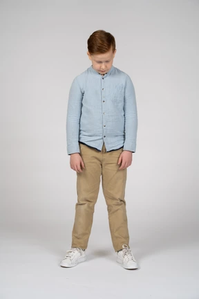 Front view of a boy in casual clothes bending head down
