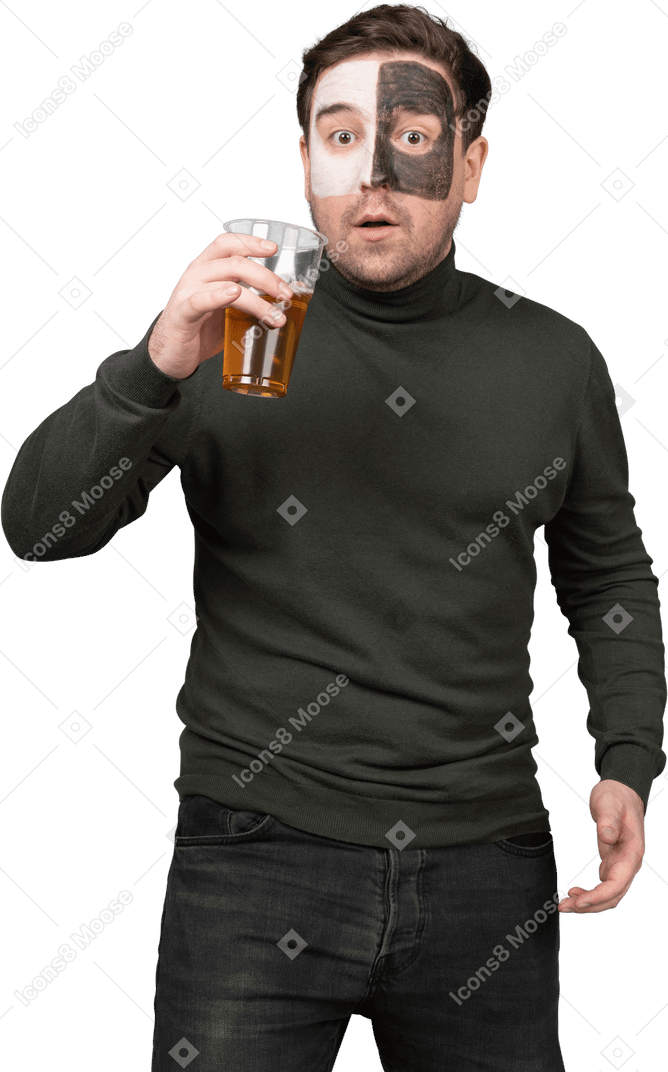 Vista frontal de un fanático del fútbol masculino sorprendido sosteniendo una cerveza