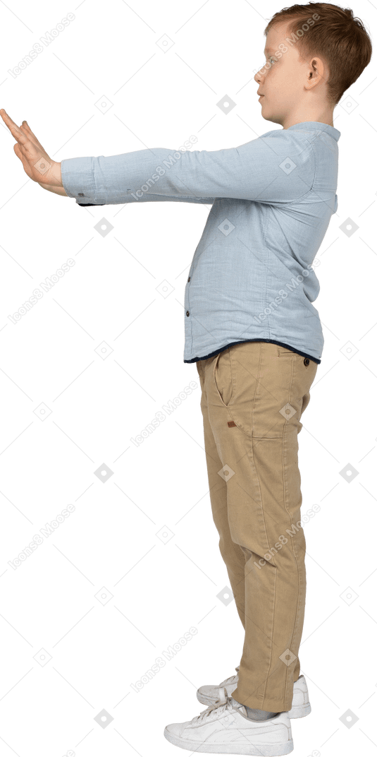 Side view of a boy making stop gesture