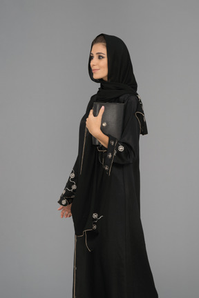 ハンドバッグを保持している若いイスラム教徒の女性