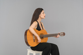 Hermosa joven tocando una guitarra
