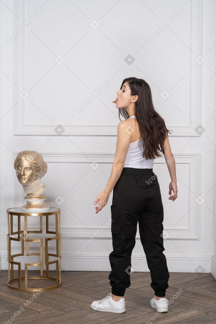 Vista traseira de uma mulher enfiando a língua para fora