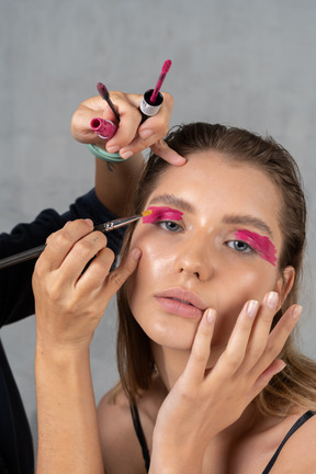 Portrait d'une femme se faisant maquiller