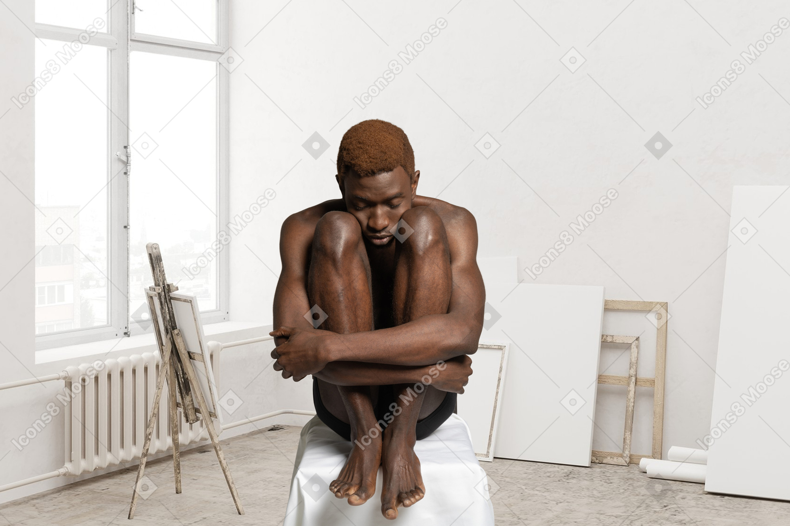A man sitting on top of a white stool