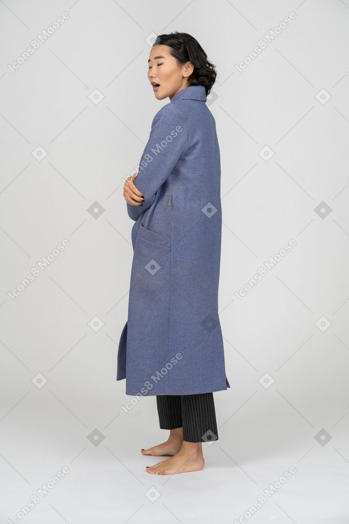 Vista lateral de una mujer con abrigo con los ojos cerrados