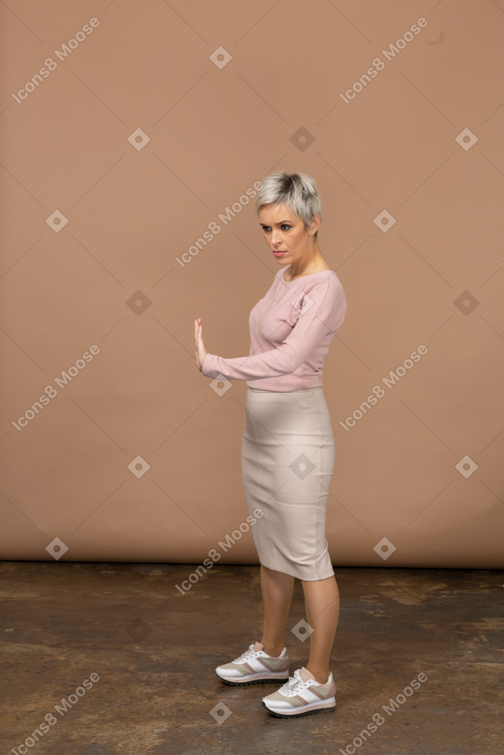 一个穿着休闲服的女人的侧视图显示停止手势