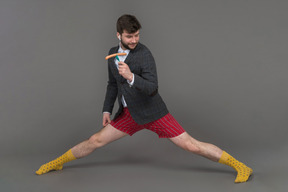 Mann in roten shorts tanzt mit einer wurst