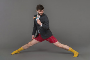 Man in red shorts dancing with a sausage