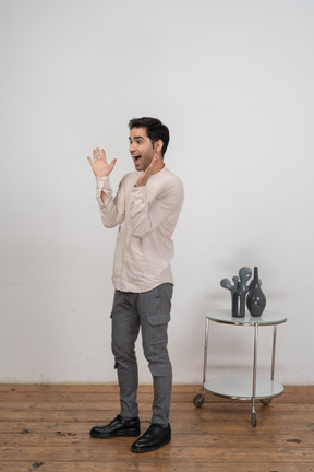 Vista frontal de um homem feliz em roupas casuais gesticulando