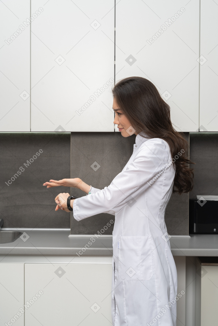 Side view of a questioning female doctor with watch