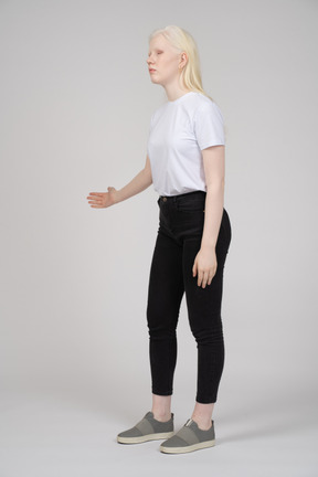 一个年轻女孩站立并伸出手臂的四分之三视图